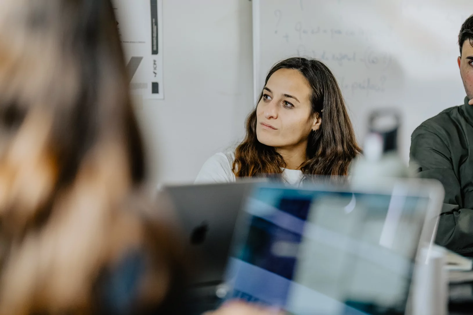Une personne suit une formation Médianes, ordinateurs ouverts et tableau blanc au fond.