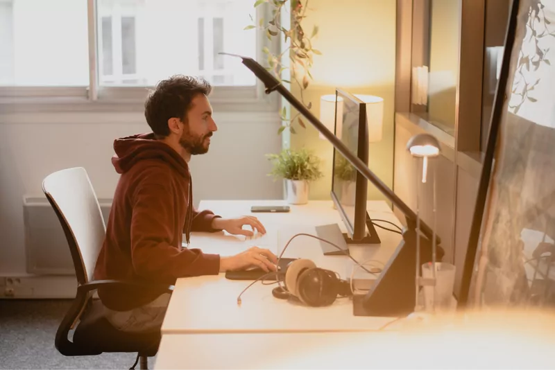 Un poste de travail du studio Médianes : deux écrans, casque et lampe d’architecte.